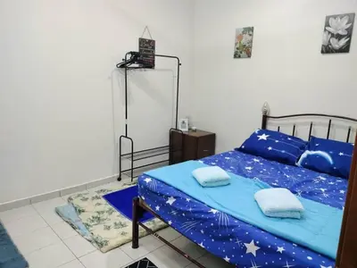 a bedroom with a bed with a blue comforter and stars at Homestay kita in Gua Sai