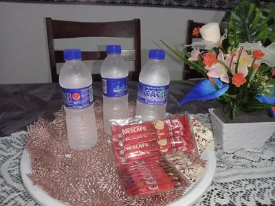 a table with three bottles of water on a plate at Homestay kita in Gua Sai