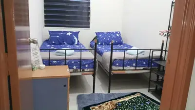 a room with three bunk beds with blue pillows at Homestay kita in Gua Sai