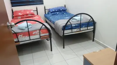 two twin beds in a small room with a table at Homestay kita in Gua Sai