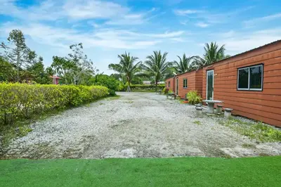 a gravel driveway next to a building with trees at Hotel O Asiacamp Chalet Tanjung Karang in Kuala Selangor