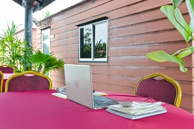a laptop computer sitting on a pink table with chairs at Hotel O Asiacamp Chalet Tanjung Karang in Kuala Selangor