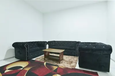 a black couch with a coffee table in a room at Hotel O Asiacamp Chalet Tanjung Karang in Kuala Selangor