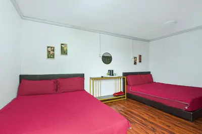 a bedroom with two beds with red sheets at Hotel O Asiacamp Chalet Tanjung Karang in Kuala Selangor