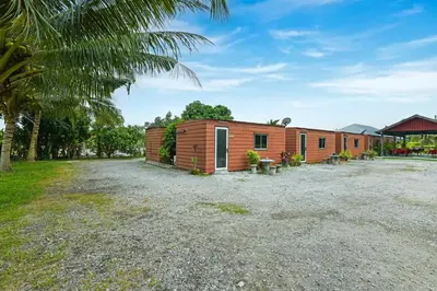 a wooden house with a gravel yard at Hotel O Asiacamp Chalet Tanjung Karang in Kuala Selangor