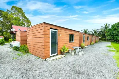 a small wooden house with a gravel driveway at Hotel O Asiacamp Chalet Tanjung Karang in Kuala Selangor