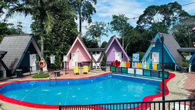 a pool in front of a group of houses at Capital O 91167 Gemilang Candi Resort in Kampong Baru
