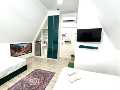 a room with two beds and a flat screen tv at Capital O 91167 Gemilang Candi Resort in Kampong Baru