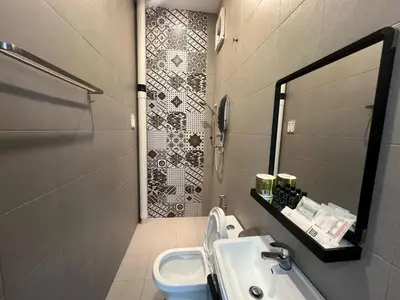 a bathroom with a sink and a toilet at Capital O 91170 Kurau Bay Hotel in Kuala Kurau
