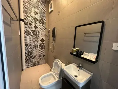 a bathroom with a sink and a toilet and a mirror at Capital O 91170 Kurau Bay Hotel in Kuala Kurau