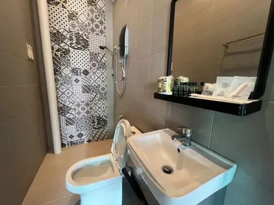 a bathroom with a sink and a toilet at Capital O 91170 Kurau Bay Hotel in Kuala Kurau