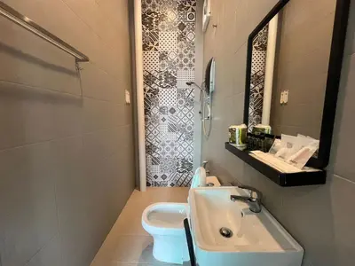 a bathroom with a sink and a toilet at Capital O 91170 Kurau Bay Hotel in Kuala Kurau