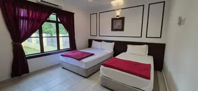 a bedroom with two beds and a window at Striatus by Holiday Pool Villa A'Famosa Resort in Gua Sai