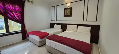 a bedroom with two beds and a window at Striatus by Holiday Pool Villa A'Famosa Resort in Gua Sai