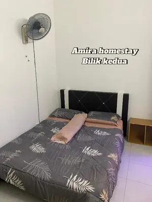 a bed in a room with a sign on the wall at Amira homestay in Kampong Batu Lima