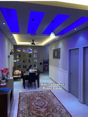 a living room with a table and a blue ceiling at Amira homestay in Kampong Batu Lima