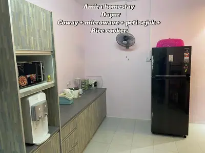 a kitchen with a black refrigerator and a counter at Amira homestay in Kampong Batu Lima