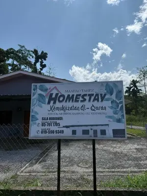 a sign in front of a house at Homestay Maahad Tahfiz Kemukjizatan Al-Quran in Gerik