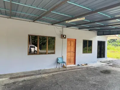 a house with a blue chair in front of a door at Homestay Maahad Tahfiz Kemukjizatan Al-Quran in Gerik