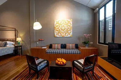 a living room with a couch and two chairs at Argus Residences in George Town