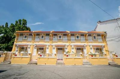 a yellow building with flowers in front of it at Argus Residences in George Town