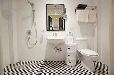a white bathroom with a sink and a toilet at Argus Residences in George Town