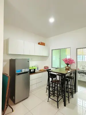 a kitchen with a table and a refrigerator at ipoh setia homestay in Ipoh
