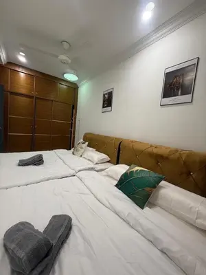 a bedroom with a large white bed with a brown headboard at Cozy Family Home Seberang Jaya in Kampong Bagan Dalam