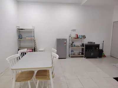 a kitchen with a white table and chairs and a refrigerator at Unit 3 Islam Taqwa Homestay in Kuala Lipis