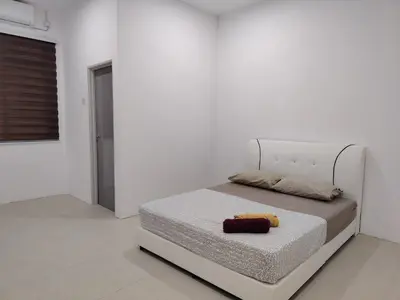 a white bedroom with a bed with a yellow towel on it at Unit 3 Islam Taqwa Homestay in Kuala Lipis