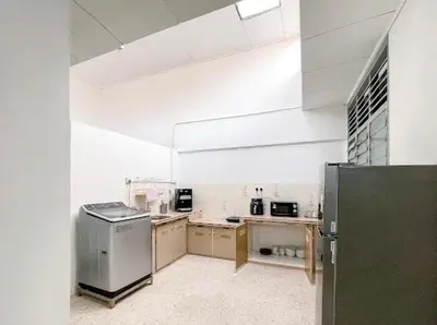 a large kitchen with a refrigerator in a room at Pearl Cottage - 2min Drive to Lam Wah Ee Hospital in George Town