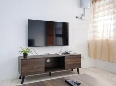 a living room with a television on a wall at Pearl Cottage - 2min Drive to Lam Wah Ee Hospital in George Town