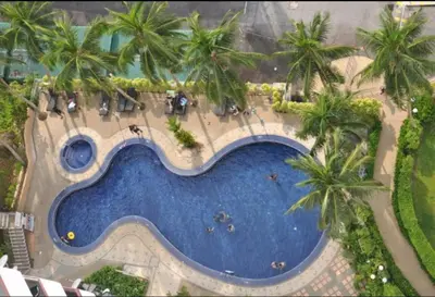 an overhead view of a swimming pool with palm trees at Seaview 3 room Apartment Batu Ferringhi in Batu Ferringhi