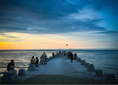 a group of people walking on the beach at Seaview 3 room Apartment Batu Ferringhi in Batu Ferringhi