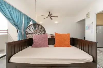 a bed with pillows and a ceiling fan at Seaview 3 room Apartment Batu Ferringhi in Batu Ferringhi