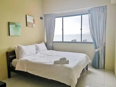 a bedroom with a bed with a large window at Seaview 3 room Apartment Batu Ferringhi in Batu Ferringhi