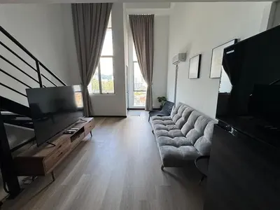 a living room with a couch and a flat screen tv at Modern Studio The CEO Penang in Bayan Lepas