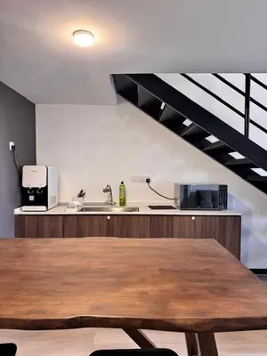 a kitchen with a wooden table and a sink at Modern Studio The CEO Penang in Bayan Lepas