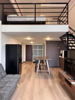 a living room with a couch and a table and a loft at Modern Studio The CEO Penang in Bayan Lepas