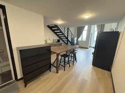 a kitchen and dining room with a table and a staircase at Modern Studio The CEO Penang in Bayan Lepas