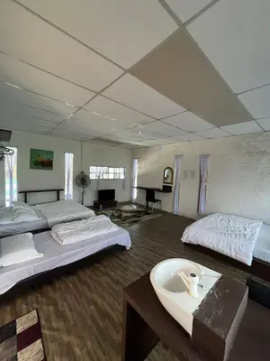 a large room with two beds and a bath tub at Galeri Merah Teratak Anak Amas in Sungai Besar