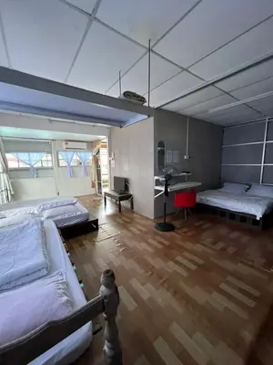 a large room with three beds and a desk at Galeri Merah Teratak Anak Amas in Sungai Besar