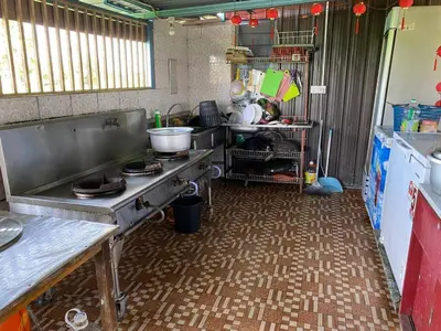 a kitchen with a stove and a table in it at Galeri Merah Teratak Anak Amas in Sungai Besar
