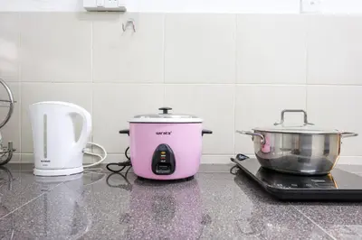 a pink slow cooker and a pot on a counter at Homestay Emerald Avenue Brinchang Cameron Highlands For 12 Pax Clover Home G23A in Brinchang