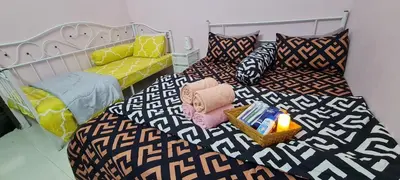 a room with two beds with pillows and a candle at Ruma Inn Homestay Perlis in Gua Sai