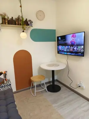 a living room with a table and a tv on the wall at Unisuites Kampar 5 min UTAR & TARC -1 BR 3pax PetFriendly, 1 Carpark & Netflix I High Floor Unblock Mountain View in Kampar