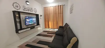 a living room with a couch and a television at ZARI Homestay Kamunting in Gua Sai