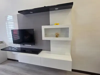 a living room with a tv on a white wall at The Anderson by Triple G Homes in Ipoh