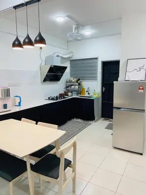 a kitchen with a table and a refrigerator at Baitul Mikhael Homestay in Kampong Ayer Melintas Besar