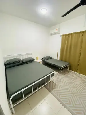 a room with a bed and a table and a couch at Baitul Mikhael Homestay in Kampong Ayer Melintas Besar